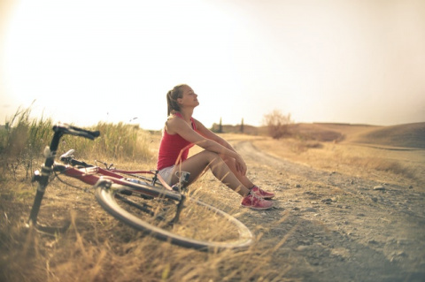 Foto de chica descansando junto a una bicicleta